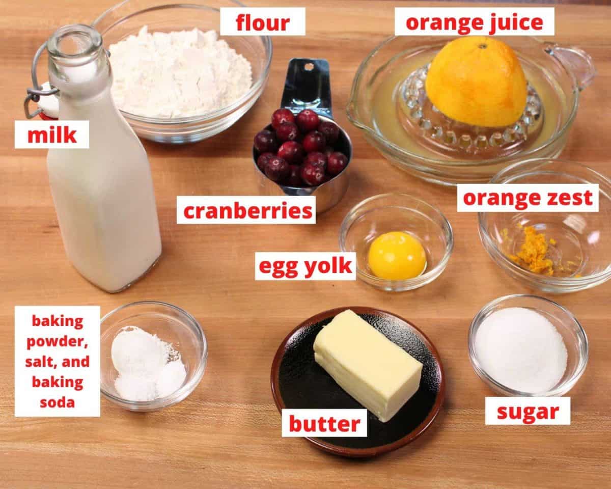 ingredients for scones; flour, butter, milk, sugar on a wooden cutting board.