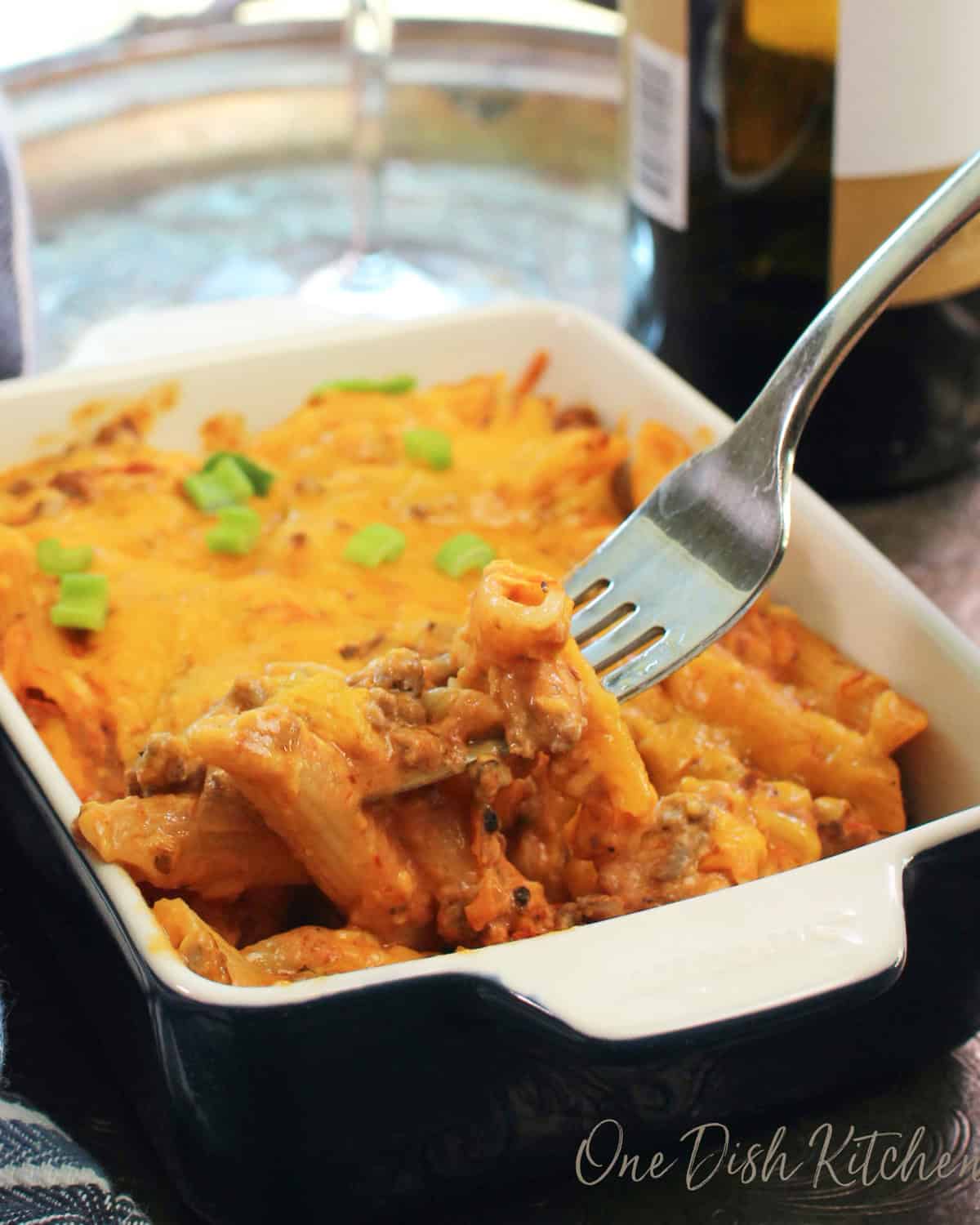 a mini hamburger casserole for one person in a small baking dish with a fork on the side.