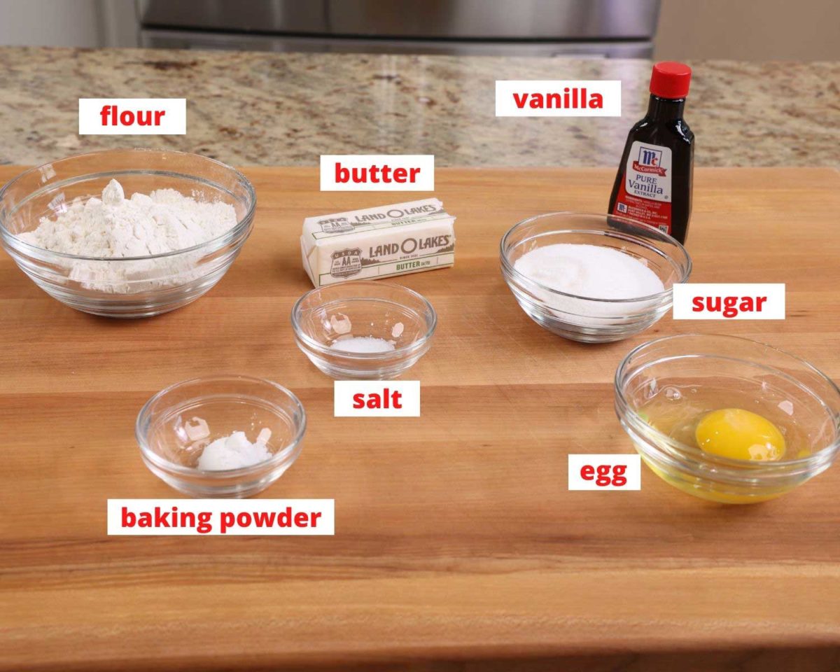 flour, egg, vanilla, butter and salt on a wooden cutting board