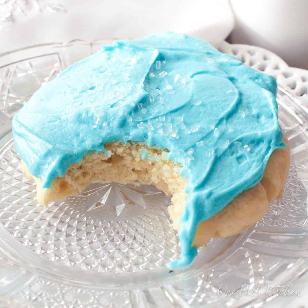 one frosted sugar cookie on a white plate.