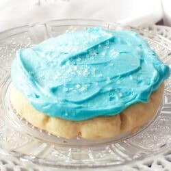 a frosted sugar cookie on a white plate.