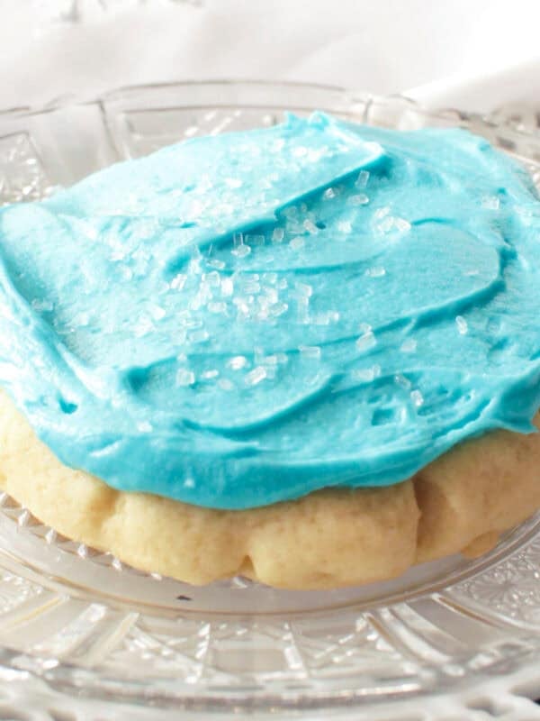 a frosted sugar cookie on a white plate.