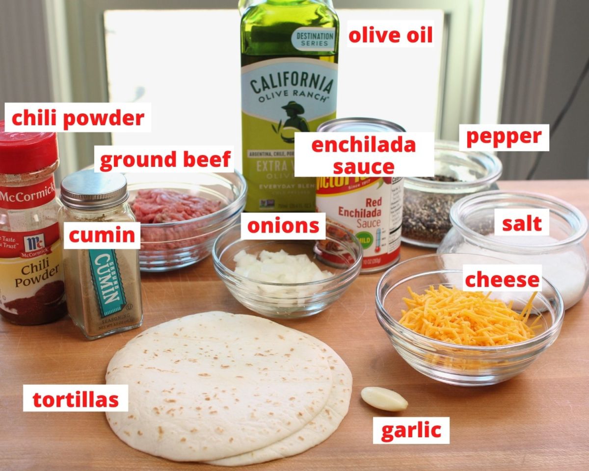 ingredients needed to make beef enchiladas labeled and on a brown cutting board.
