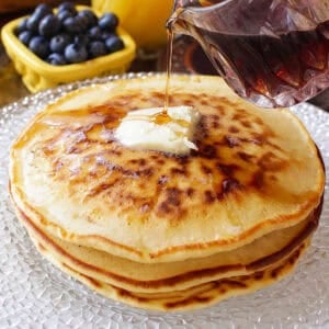 three pancakes on a plate made with homemade pancake mix, topped with butter and syrup.