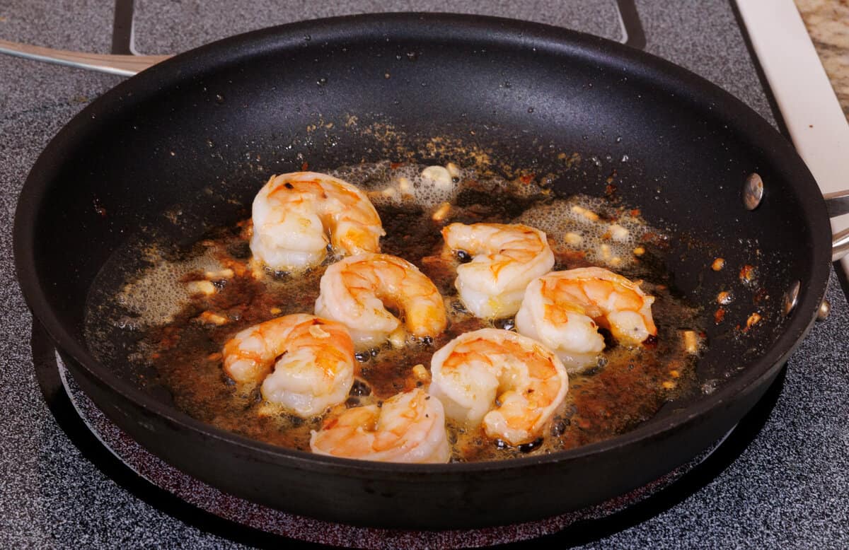 7 shrimp cooking in a skillet.