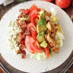 a single serving cobb salad with chicken, bacon, eggs, blue cheese, avocado and tomatoes tossed in a cobb salad vinaigrette.