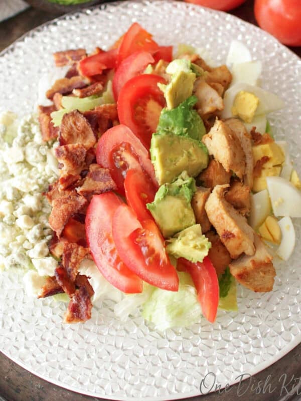 a single serving cobb salad with chicken, bacon, eggs, blue cheese, avocado and tomatoes tossed in a cobb salad vinaigrette.