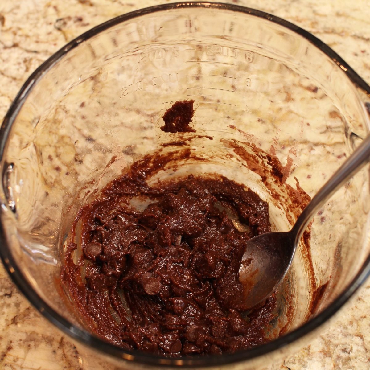 brownie batter in a mixing bowl with chocolate chips mixed in.