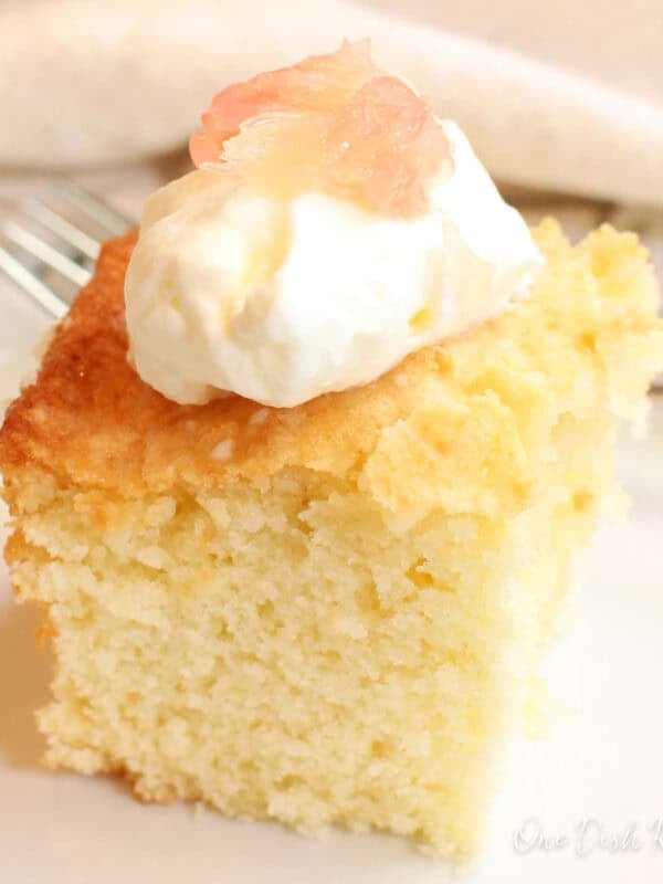 a slice of grapefruit cake with grapefruit glaze on a white plate.