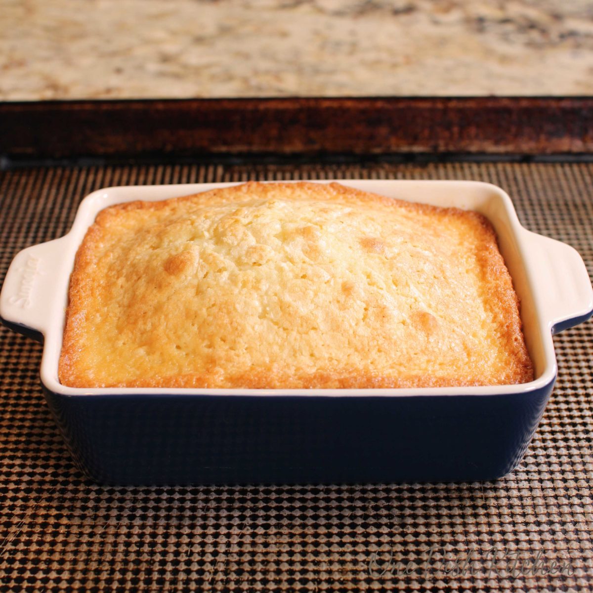 a cake in a blue baking dish on a baking sheet.