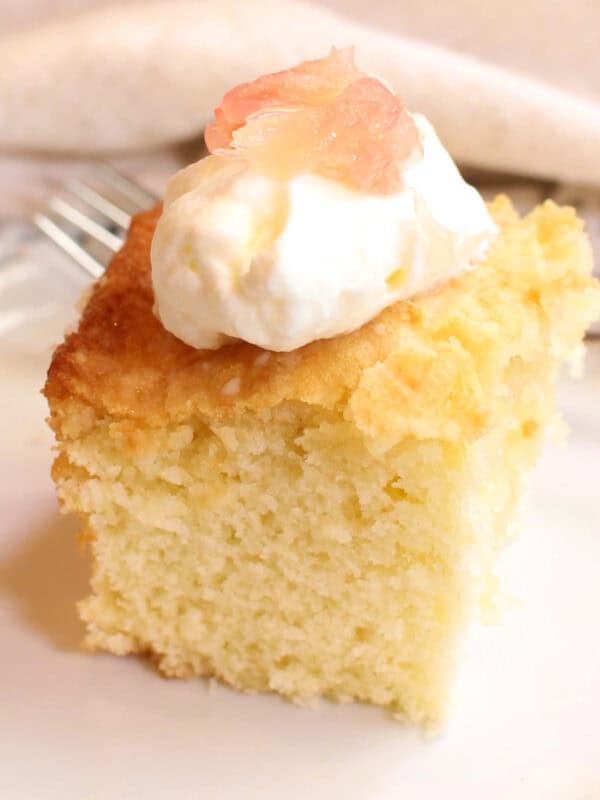 a small slice of grapefruit cake on a white plate.