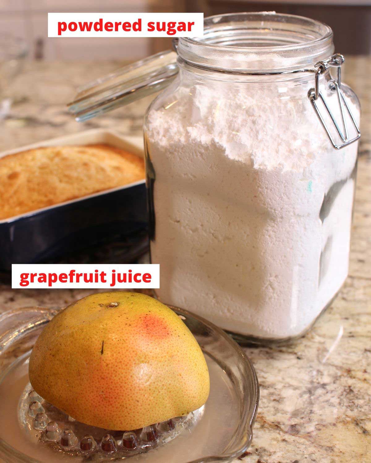 powdered sugar in a jar and a half of a grapefruit on a glass juicer on a brown kitchen counter.