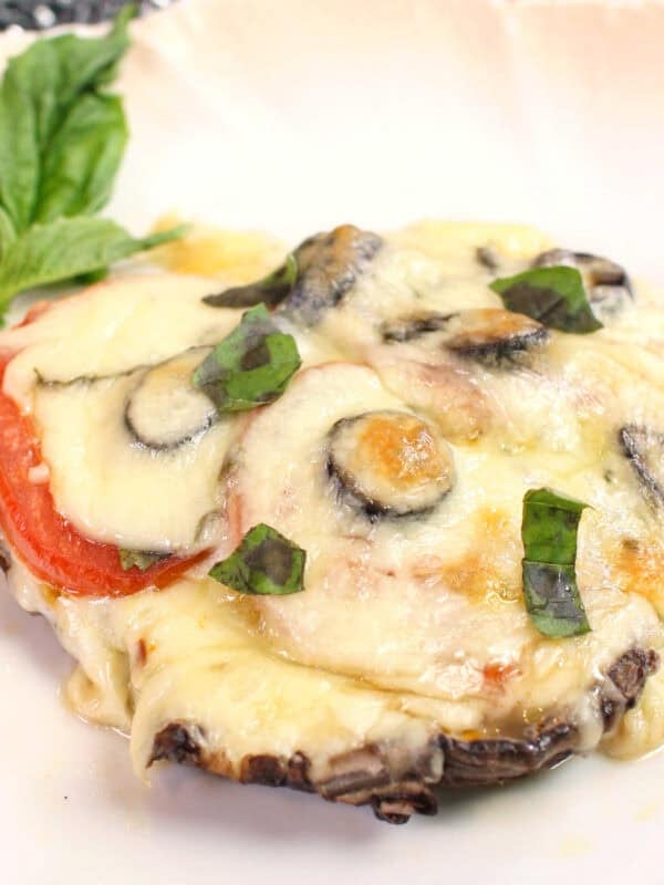 a single portobello mushroom pizza with fresh tomatoes and mozzarella cheese.