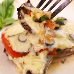 a large portobello mushroom topped with cheese and tomatoes