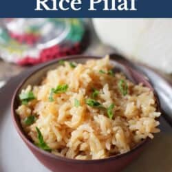 a bowl of rice pilaf next to a multi-colored napkin.