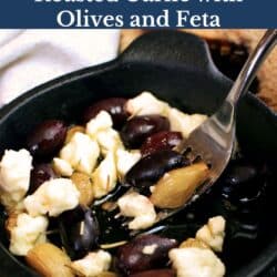 a bowl of roasted garlic with warm olives and melted feta cheese.