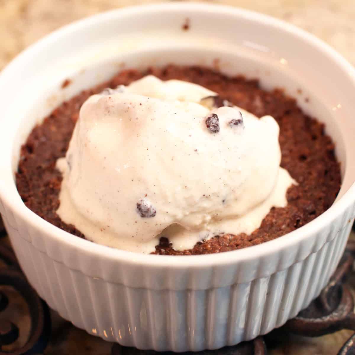 one brownie in a ramekin topped with ice cream.