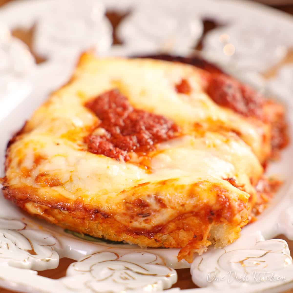 a slice of detroit style pizza on a white plate.