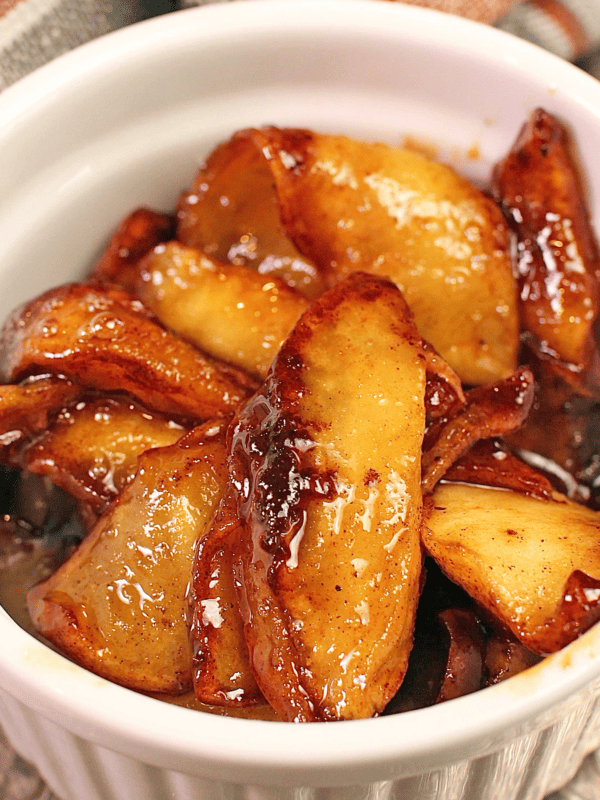 a small white bowl filled with softened cinnamon apples.