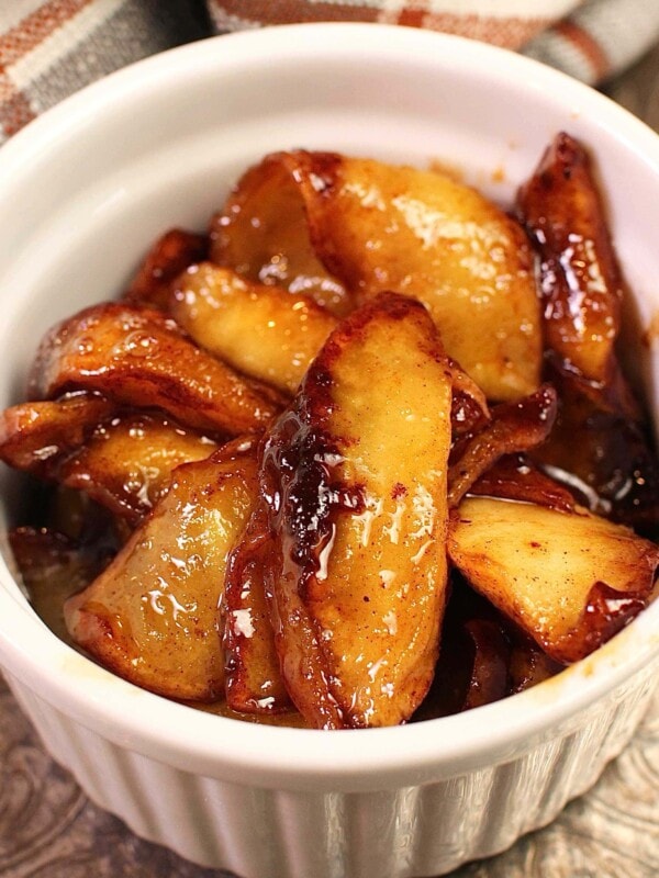 a small white bowl filled with softened cinnamon apples.