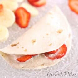 a single fruit quesadilla filled with sliced strawberries.
