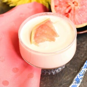 a pudding in a small clear glass topped with a grapefruit segment