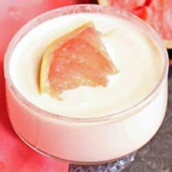 a pudding in a small clear glass topped with a grapefruit segment.