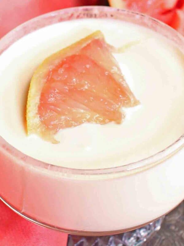 a pudding in a small clear glass topped with a grapefruit segment.
