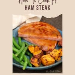 a glazed ham steak on a plate with green beans.