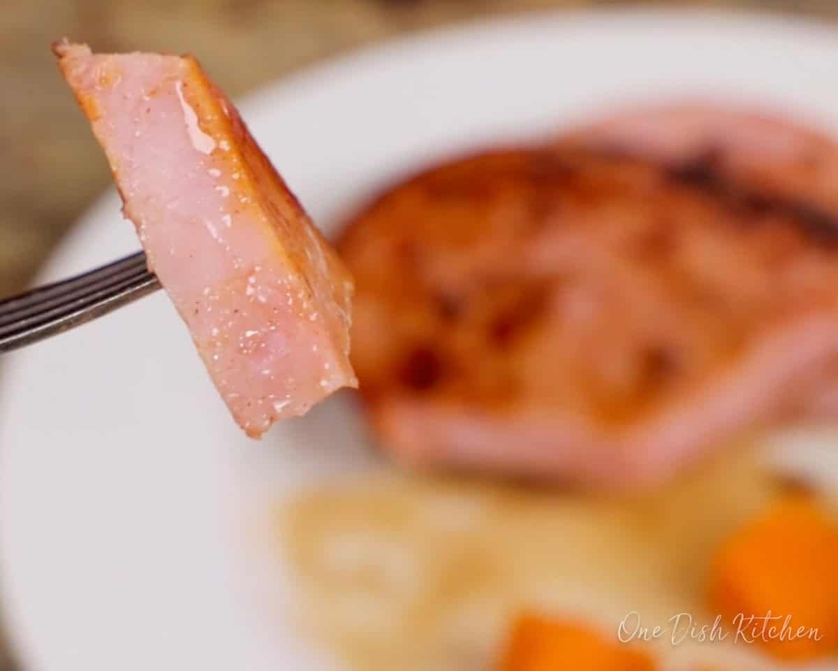 a fork holding a piece of ham.