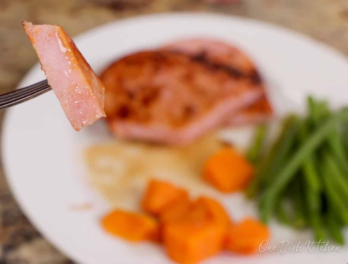 a fork holding a piece of ham.