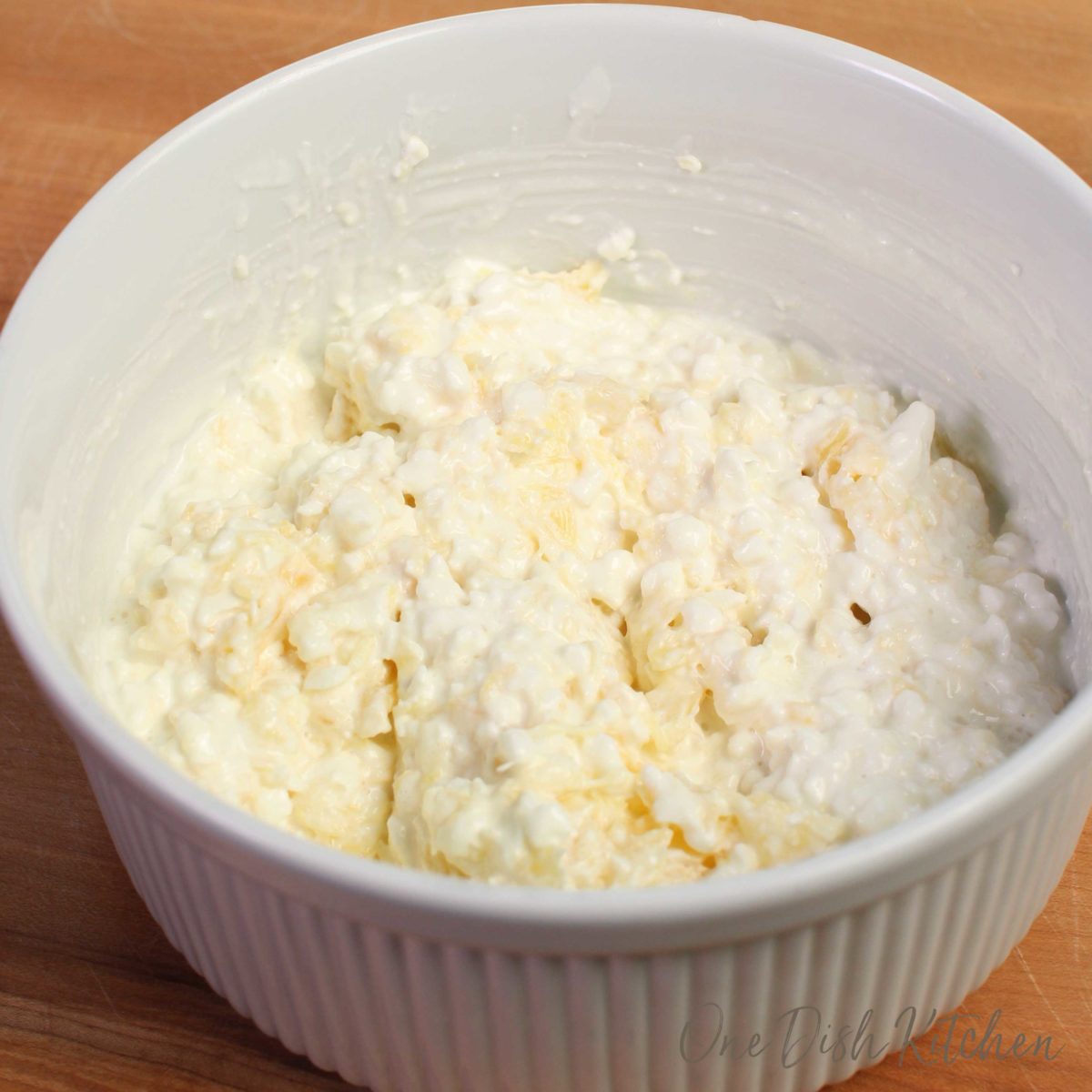 a white bowl filled with cottage cheese and crushed pineapples