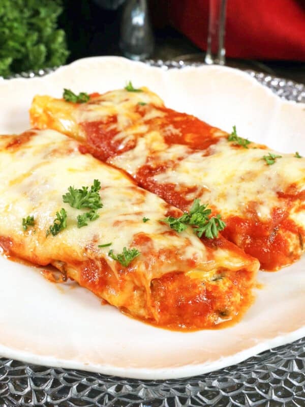 a single serving of spinach manicotti on a white plate.