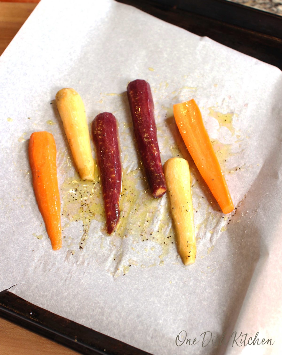 rainbow carrots on a parchment lined baking sheet.