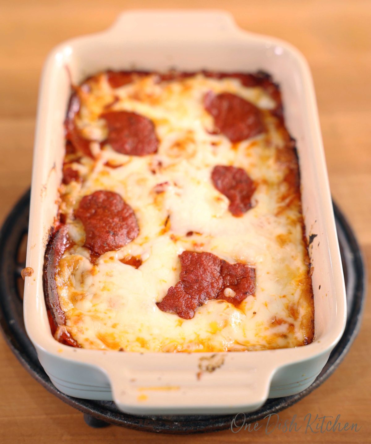 a small detroit style pizza in a blue rectangular baking dish.