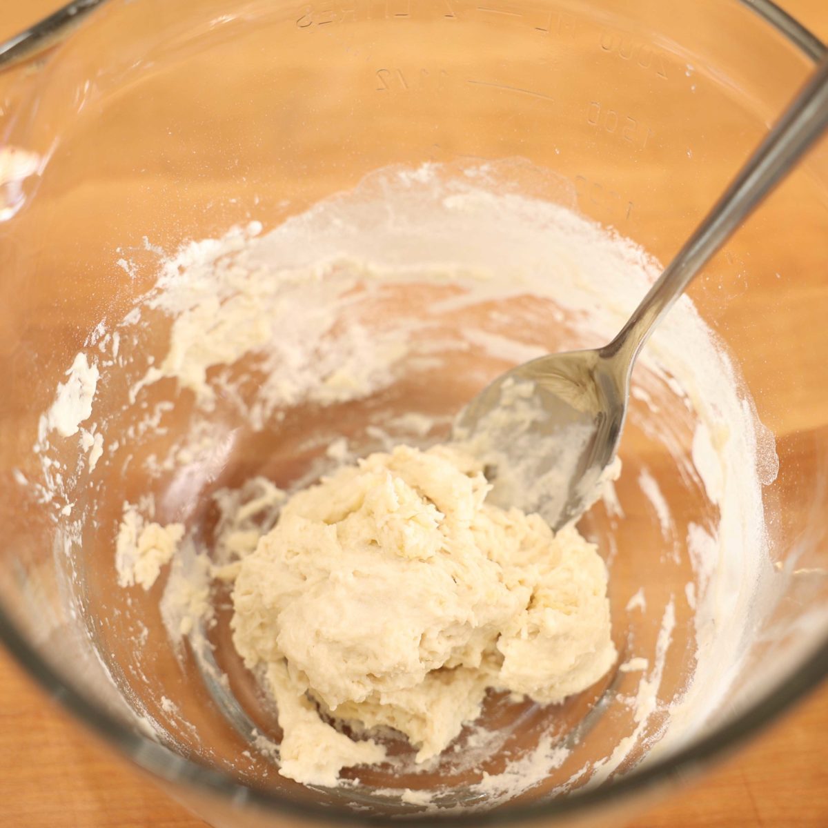 wet pizza dough in a large mixing bowl.