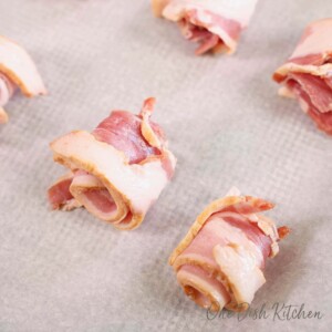 uncooked bacon slices wrapped in rolls