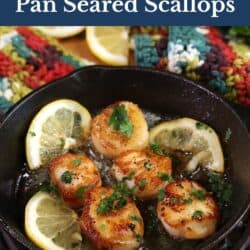 five scallops cooking in a cast iron skillet.