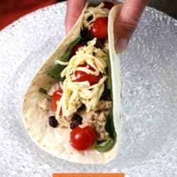 a tortilla filled with ground chicken, beans, tomatoes, and spinach.