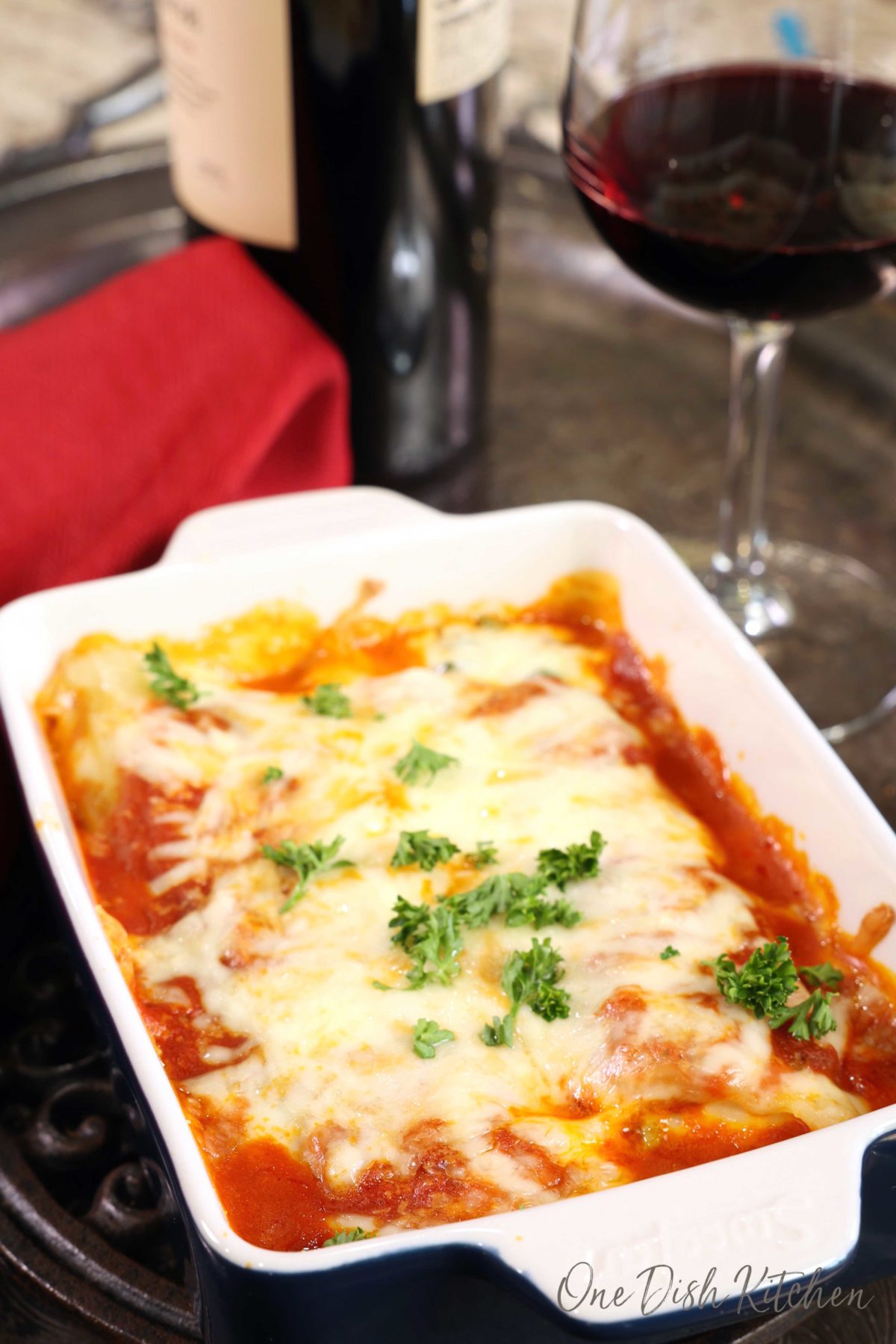 a rectangular baking dish filled with stuffed manicotti and covered with melted mozzarella cheese.
