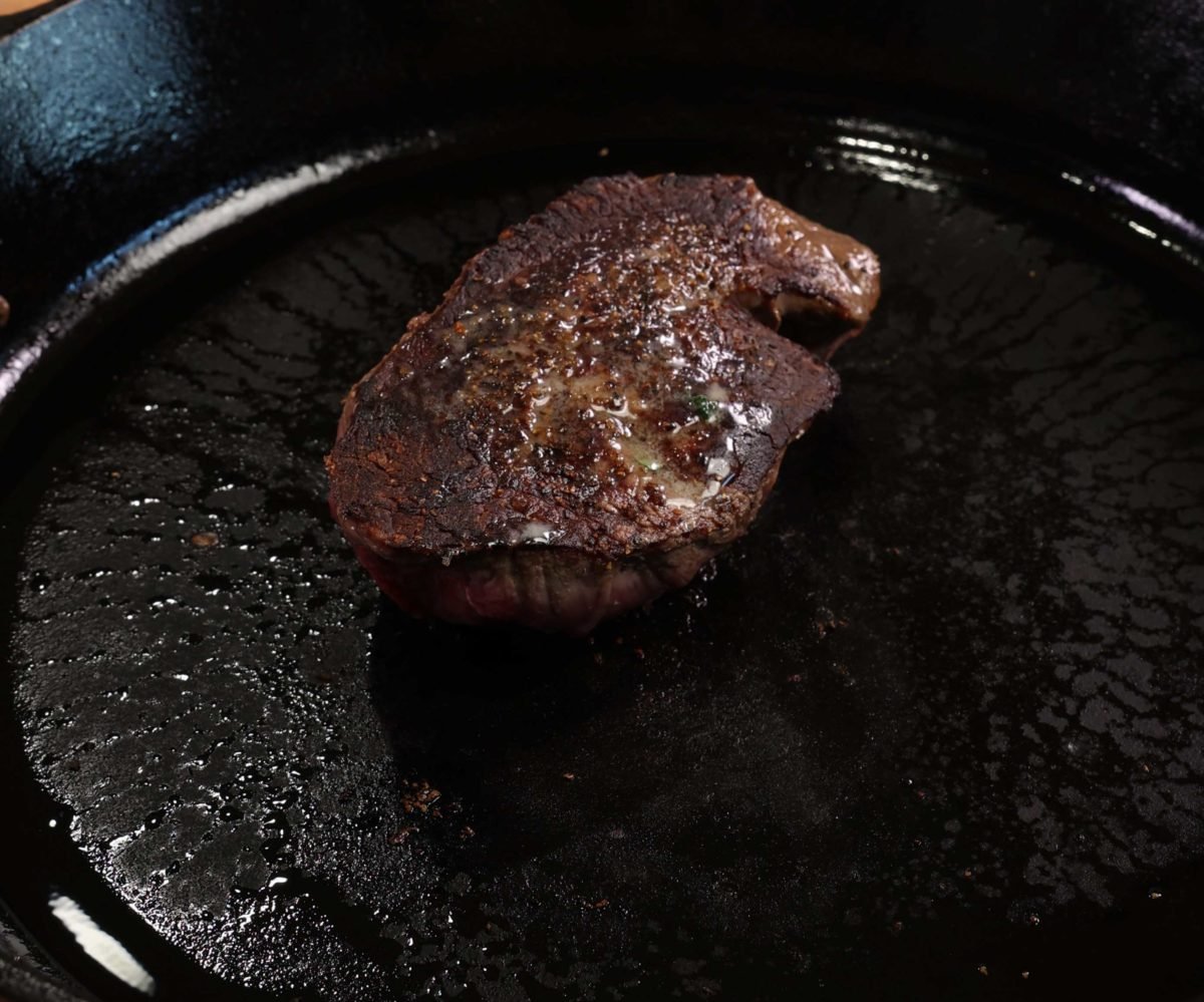 a seared beef tenderloin steak in a cast iron skillet.