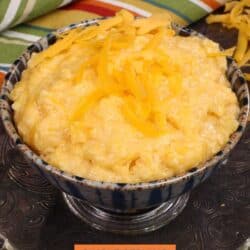 a bowl of cheese grits next to a colorful napkin on a silver tray.