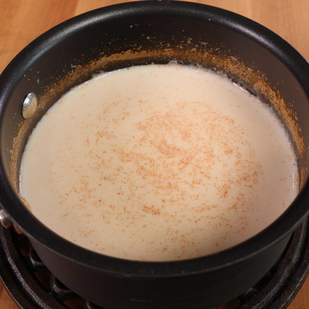 milk, water, smoked paprika and garlic powder in a small black saucepan.