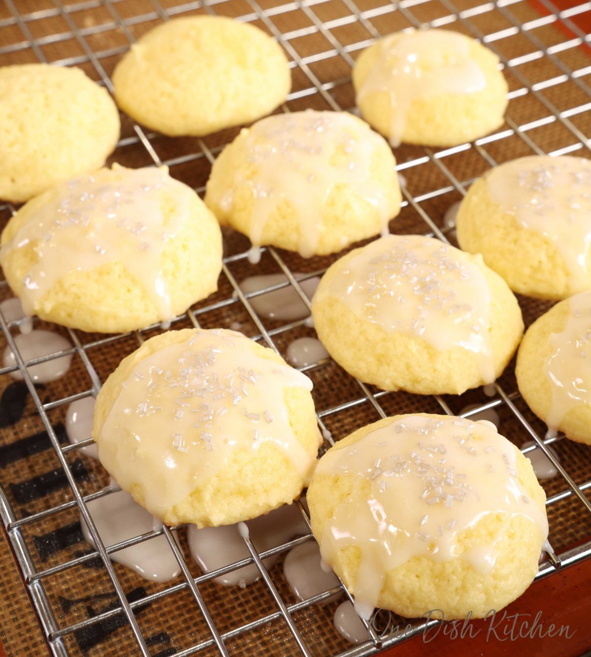 ricotta cookies topped with a sugar glaze and sprinkles on a cooling rack.
