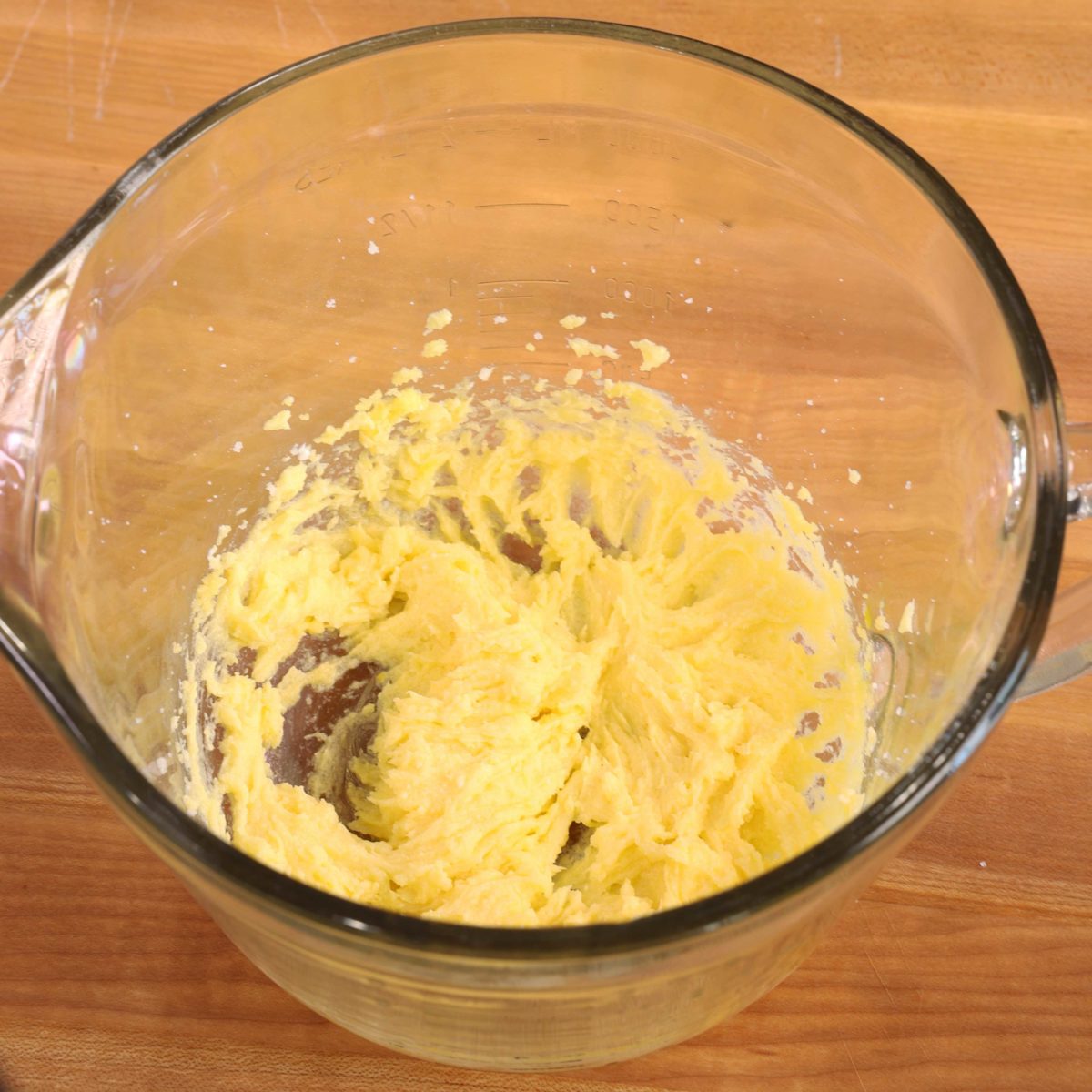 an egg mixed with softened butter and sugar in a large mixing bowl.