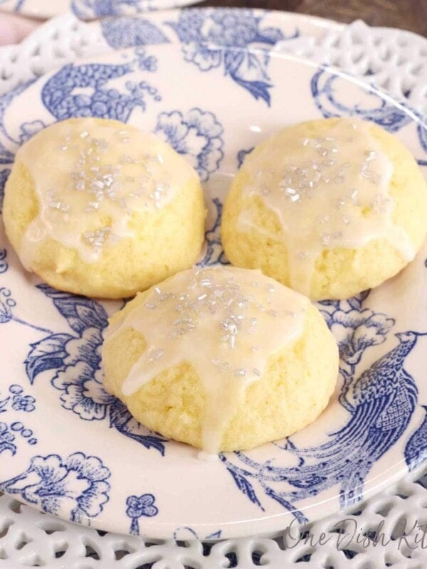three ricotta cookies with a glaze on top of a white and blue plate