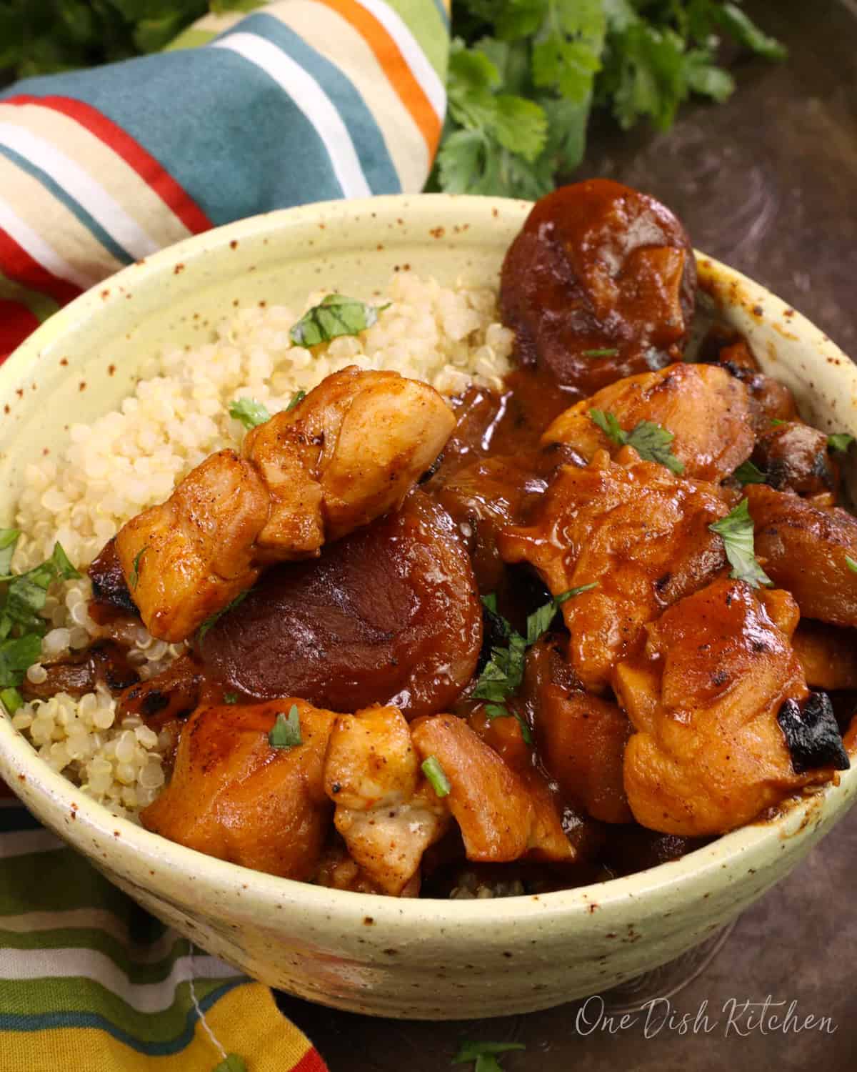 chicken tagine with apricots over quinoa in a bowl.