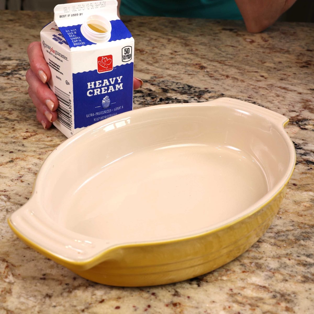 a carton of heavy cream and an oval baking dish