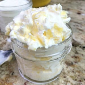 a jar of homemade clotted cream on a kitchen table.