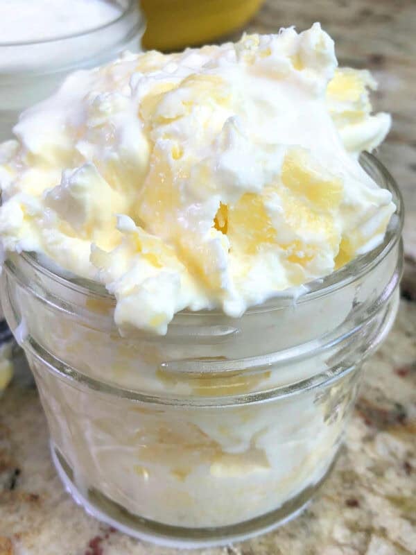 a jar of homemade clotted cream on a kitchen table.